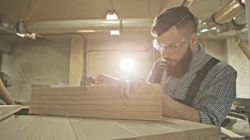 Focus on Calipers Measuring a Board in the Hand of a Lessinfocus Carpenter on the Light of His
