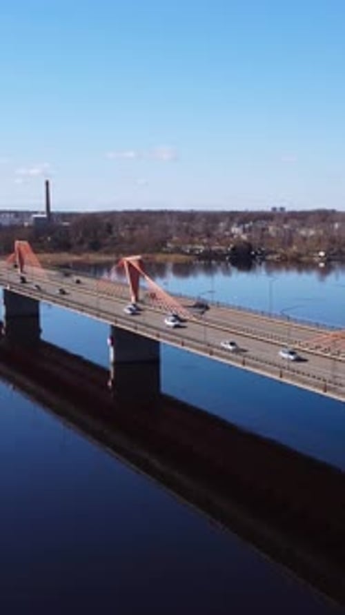 Vertikale Drohnenaufnahme einer Brücke über einen Fluss am Stadtrand. Schrägseilbrücke
über