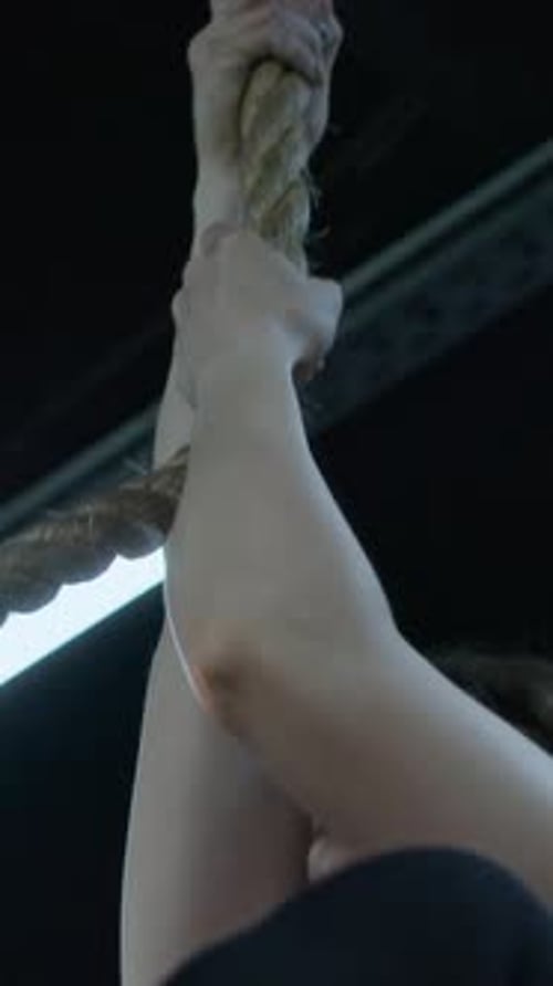 Strong Young Female Bodybuilder Climbing up Rope and Going down