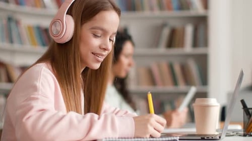 Comfortable Learning Young Lady Listening to Music Via Headphones and Writing Homework Studying in
