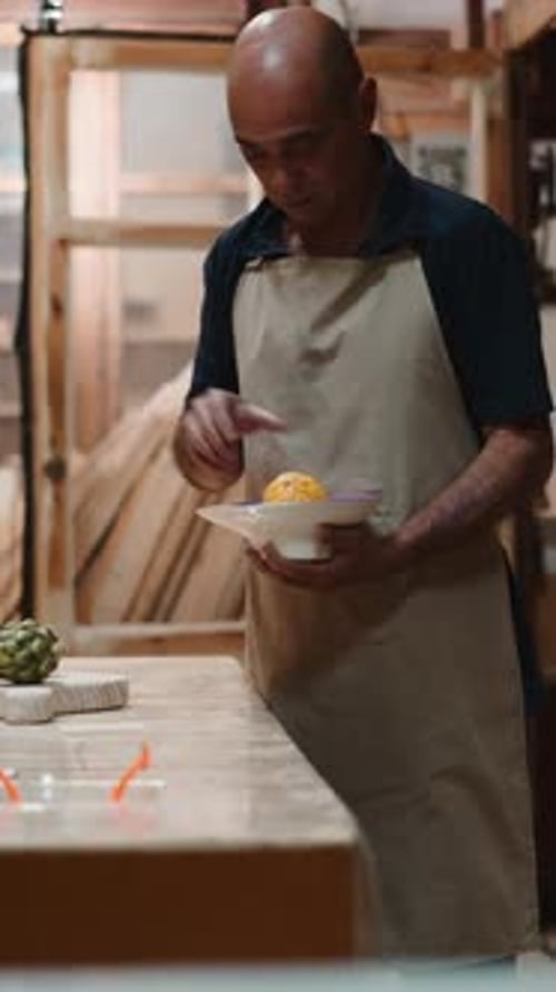 Artisan Carpenter Checking a Wooden Bowl and Fruit in His Woodworking Workshop