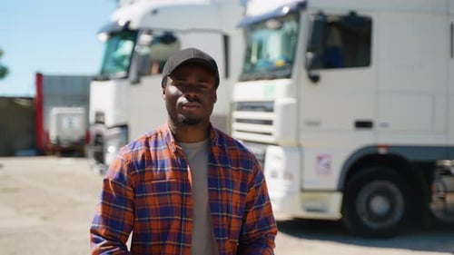 African American Truck Driver Walks Through a Parking Lot