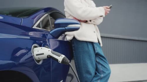 Woman using phone while car charges