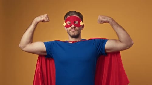 Portrait d'un homme vêtu d'un costume de super-héros démontrant des bras forts