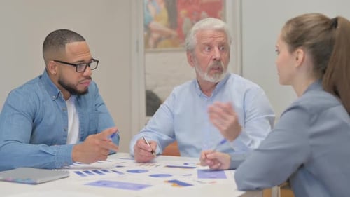 Business Colleagues Talking and Looking at Charts