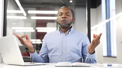 Adult Meditating at Desk in Modern Office