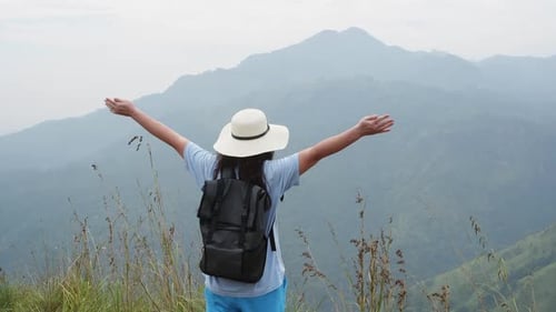 Carefree Happy Tourist Woman Rising Hands Up in Mountain Valley Enjoying Hiking