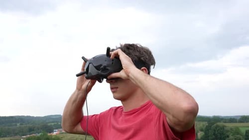 Young Man Placing Goggles Headset With Antennas on His Head, Virtual Reality and FPV Concept