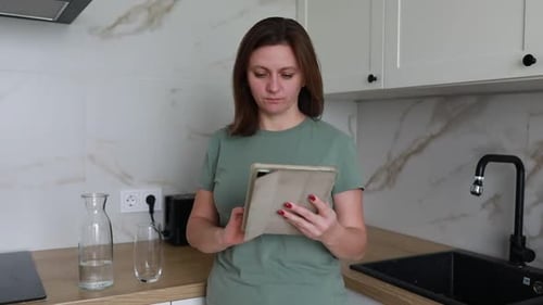 Woman Using Tablet in Modern Kitchen