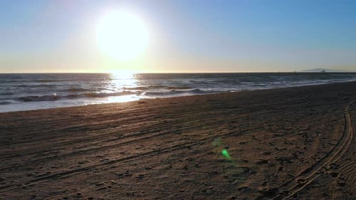 Fast fly by lifeguard tower into ocean waves and beautiful sunset with aerial 4k drone at Huntington