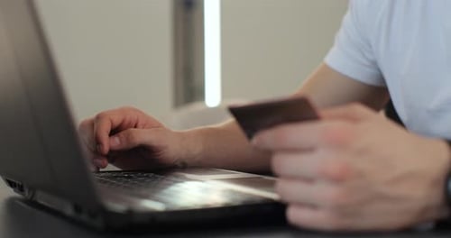 Nahaufnahme eines Mannes, der den Kreditkartencode gedrückt hat, um online über den Laptop Commerce Lifestyle zu bezahlen