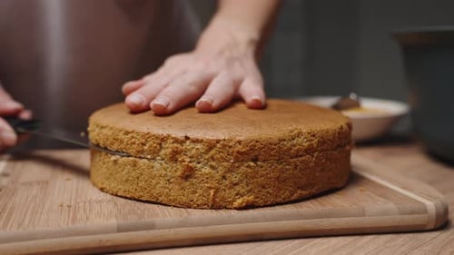 Woman Cuts Round Cake on a Board