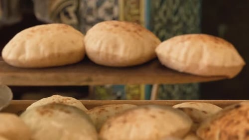 Freshly Baked Bread Being Taken Out Of Traditional Oven on Wooden Paddle and Served in Bakery