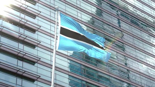Botswana Flag Waving in Front of Modern Corporate Building
