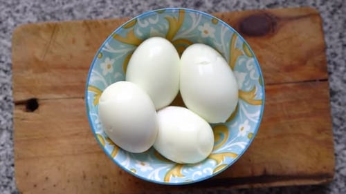 Top View Of Whole Hard-Boiled Eggs In A Bowl In The Kitchen. High Angle Shot