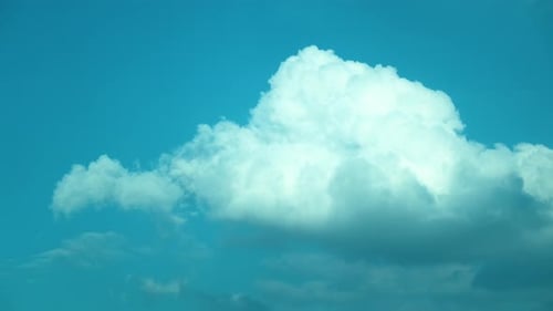 Timelapse of magnificent flowing white clouds in blue sky