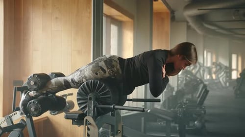 Fit Young Woman Exercises on Glute Ham Developer in Fullyequipped Gym