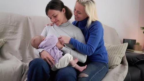Two Women With Baby Sitting On Sofa