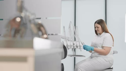 Professional Dentist in Modern Clinic Using Dental Tools