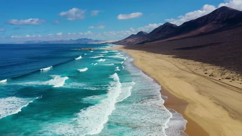 Luftaufnahme des tropischen Strandes, Blick von oben auf den Wellenbruch am tropischen gelben Sandstrand. Nahtlose Meereswellen