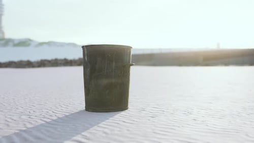 Gray Metal Garbage Bin or Trash Can on the Beach