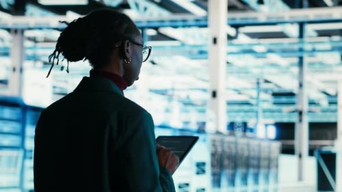 Software Developer Walks in Data Center Using Tablet and AR Technology