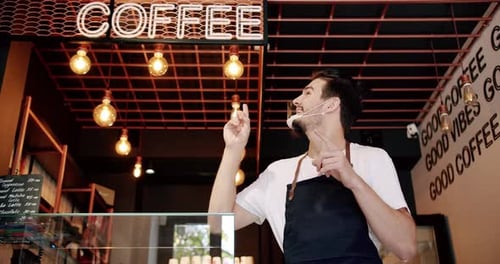 Content Young Guy Smiling During Work in Coffee Shop
