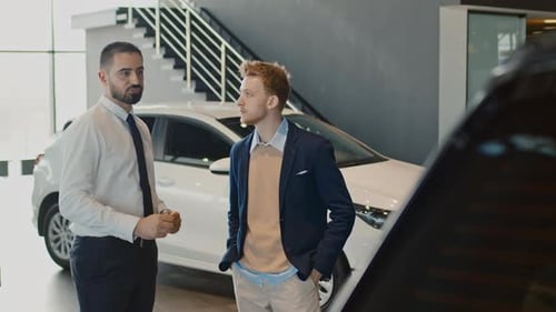 Car Salesman Talking to Customer at Dealership