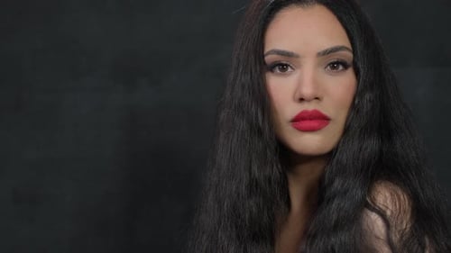 Um retrato elegante com lábios vermelhos ousados e cabelos longos e esvoaçantes que cativa o espectador