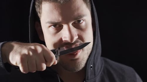 Aggressive vagrant man has a knife in his hand.
