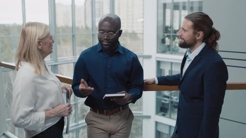 Diverse Team of Investors Communicating in Hall of Modern Office