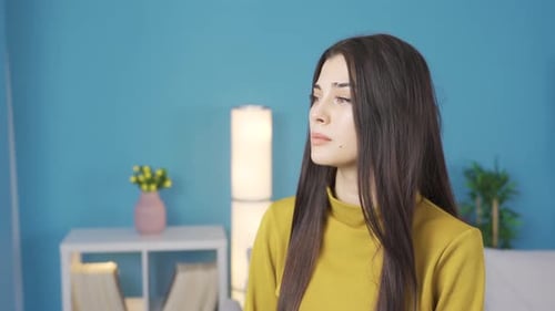 Sad woman looking at camera thoughtfully and worried.