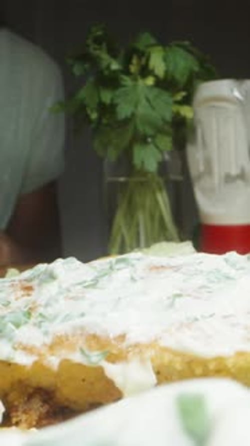 Vidéo verticale. Elle prépare des hamburgers faits maison et étale de la sauce sur les galettes. Dolly Slider
.