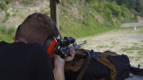 Retrato de un hombre disparando un rifle de largo alcance. De cerca