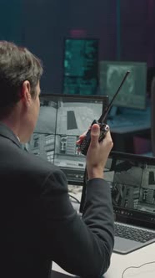 Man Communicates via Radio in Dark Office