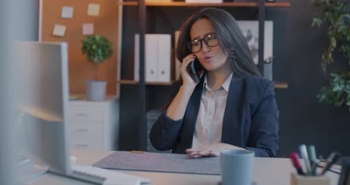 Confident Businesswoman Speaking on Cellphone Holding Mobile Discussing Work in Office