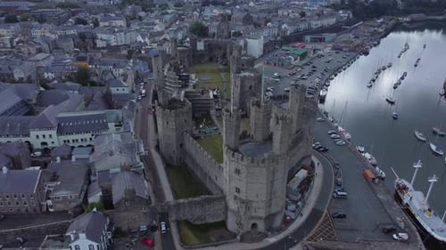 Ancient Caernarfon castle Welsh harbour town aerial view medieval waterfront landmark overlooking ri