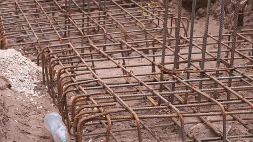 Large steel cages as reinforcement for a footing foundation on a construction site
