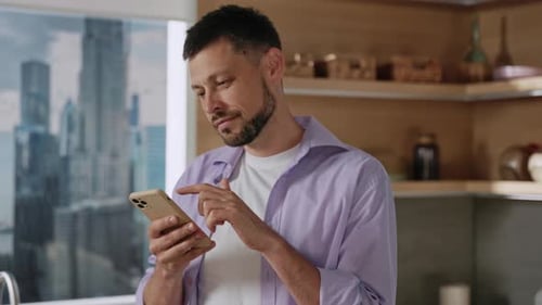 Man Using Smartphone in Urban Kitchen Setting