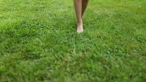 Chica desconocida en cámara lenta corriendo descalza en un prado verde en verano