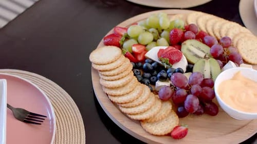 Assiette de service composée d'un assortiment de fruits, de fromages et de craquelins pour la cueillette