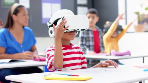 In school, boy using VR headset in classroom with teacher and students