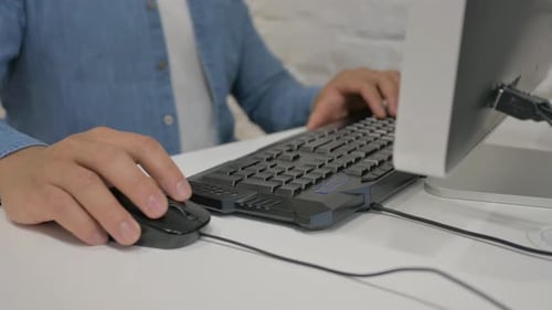 Close up of Man Typing on Keyboard and using Mouse