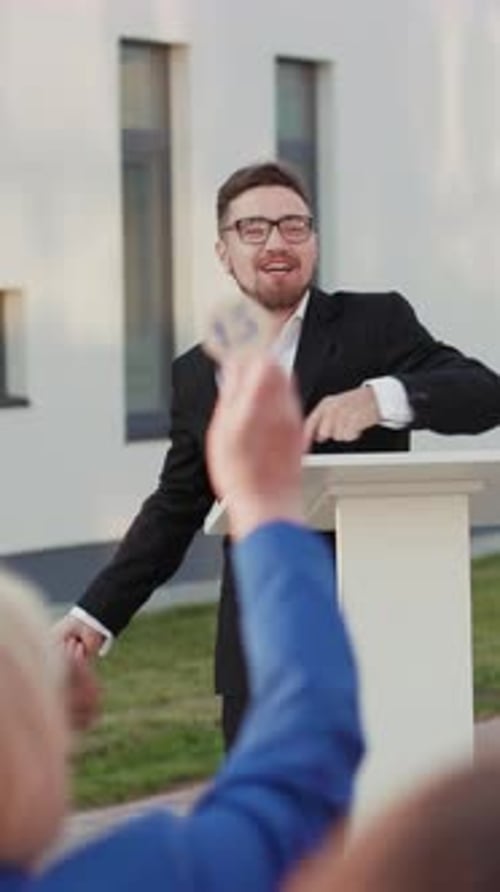 Auctioneer With Gavel Leads Bidding in Front of Crowd