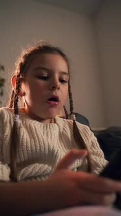 Girl Uses Mobile Phone on Couch Indoors at Night