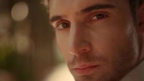 Beau marié posant sous une arche dans le jardin un portrait d'un homme romantique à l'extérieur