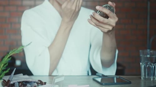 Young Adult Applying Makeup with Brush and Mirror