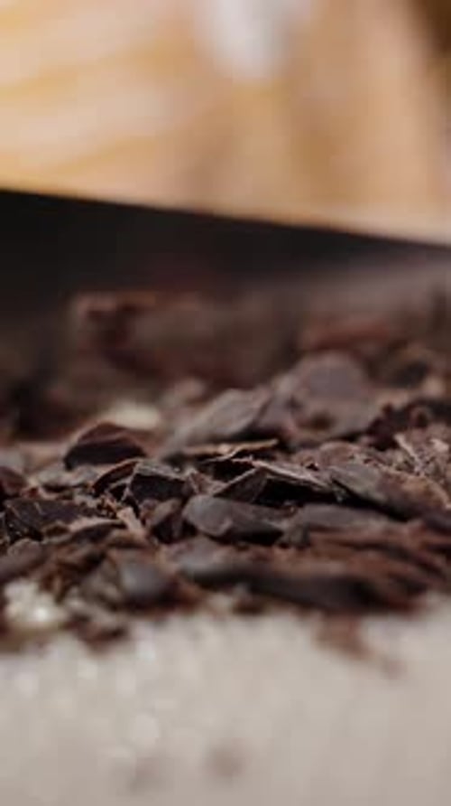 Vertical video. A Woman Presses Down On A Knife And Chops Chocolate, Slow Motion Macro, Circular