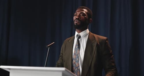 Man in Suit Speaking at a Podium Close Up