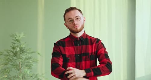 Man in Flannel Rolling Up Sleeves Indoors